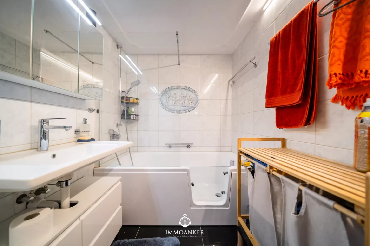 Helles Badezimmer mit Badewanne und großer Spiegelwand