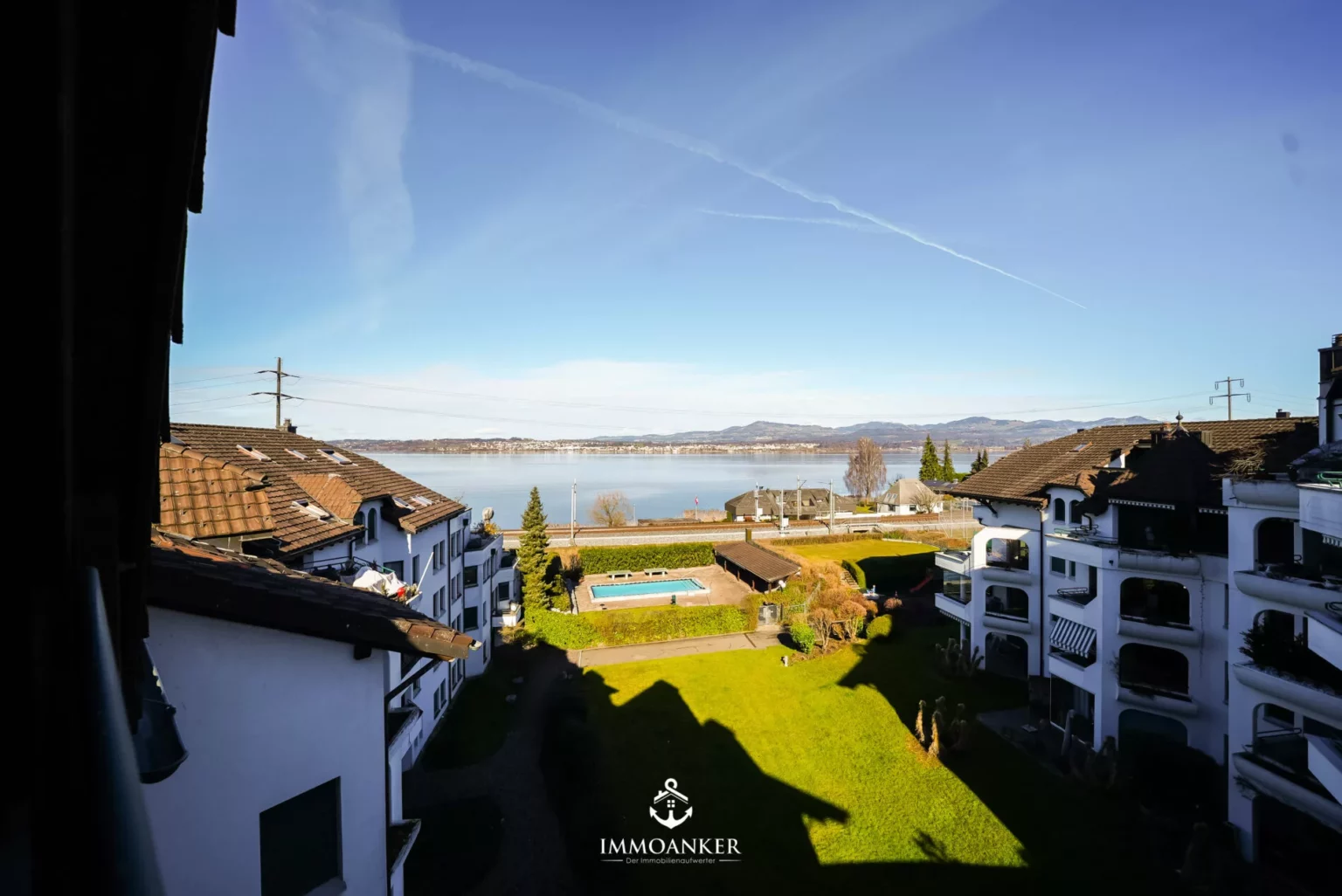 Seeblick von einem Wohngebäude mit Innenhof und Pool