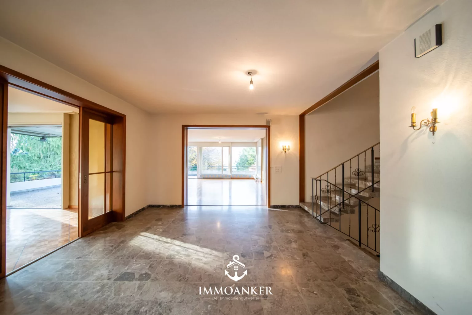 Heller Eingangsbereich mit Treppe und Durchgang zum Wohnraum