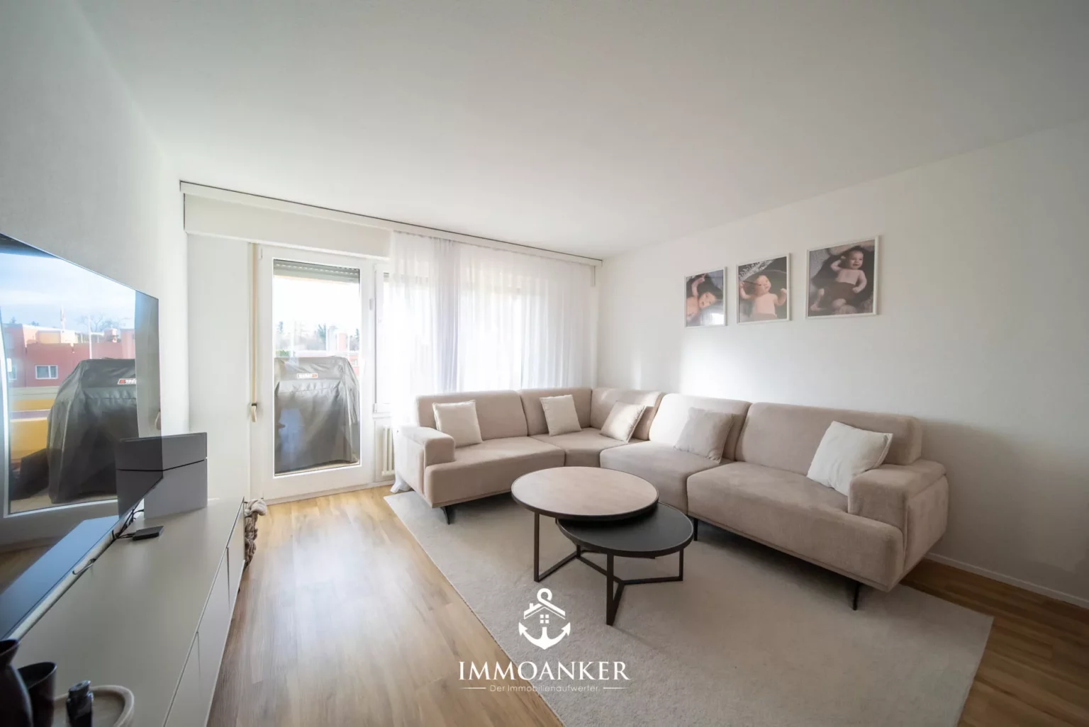Helles, modernes Wohnzimmer mit Ecksofa und Balkonzugang