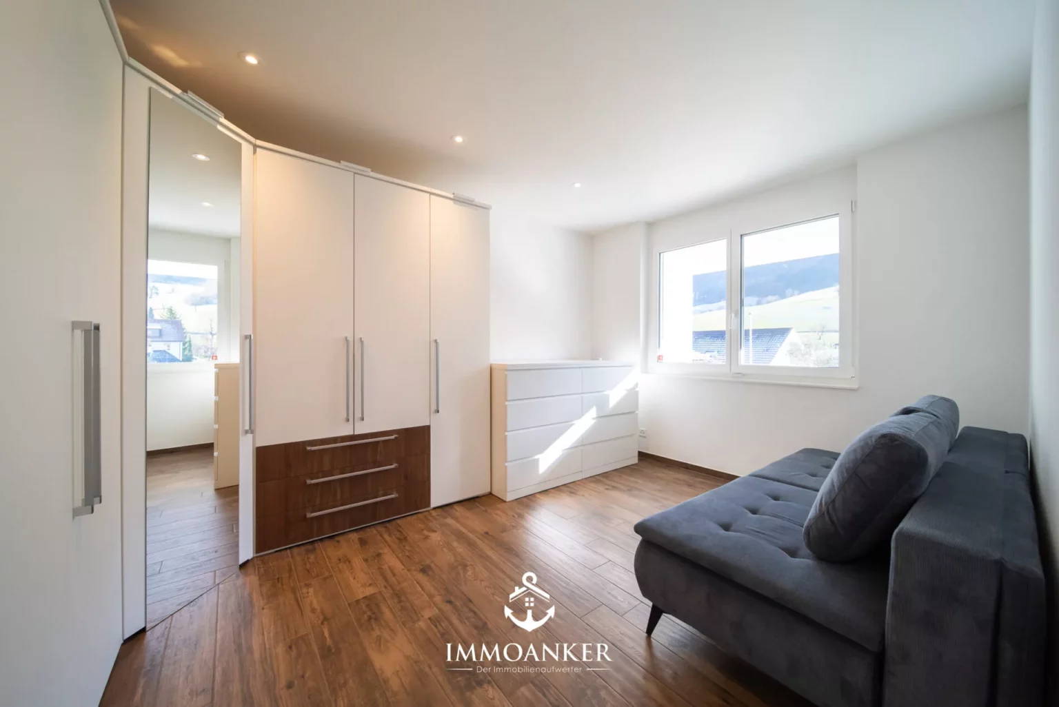 Helles Schlafzimmer mit Einbauschrank und Sofa
