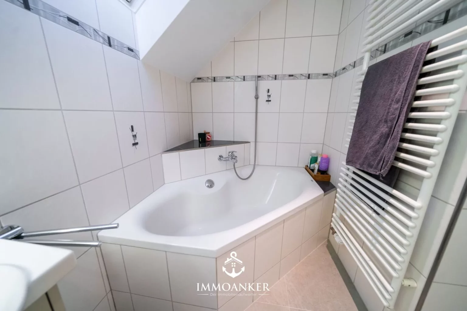 Badezimmer mit Badewanne und Handtuchheizkörper
