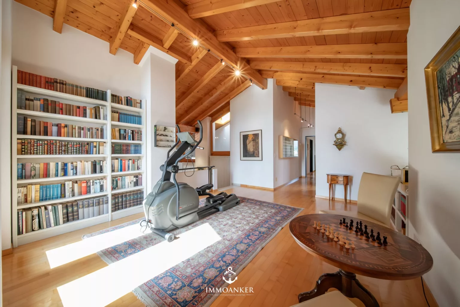 Heller Wohnraum mit Holzdecke und Bibliothek