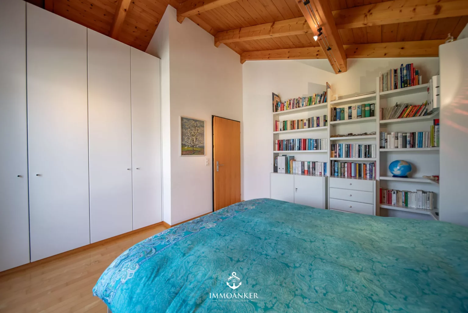 Schlafzimmer mit Holzdecke und Bücherregalen