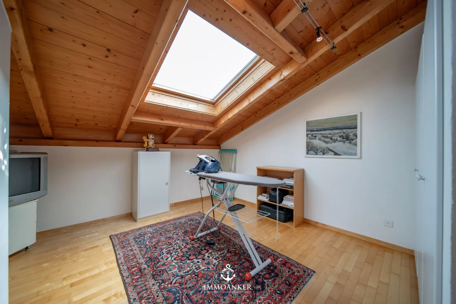 Dachgeschossraum mit Holzbalken und Dachfenster