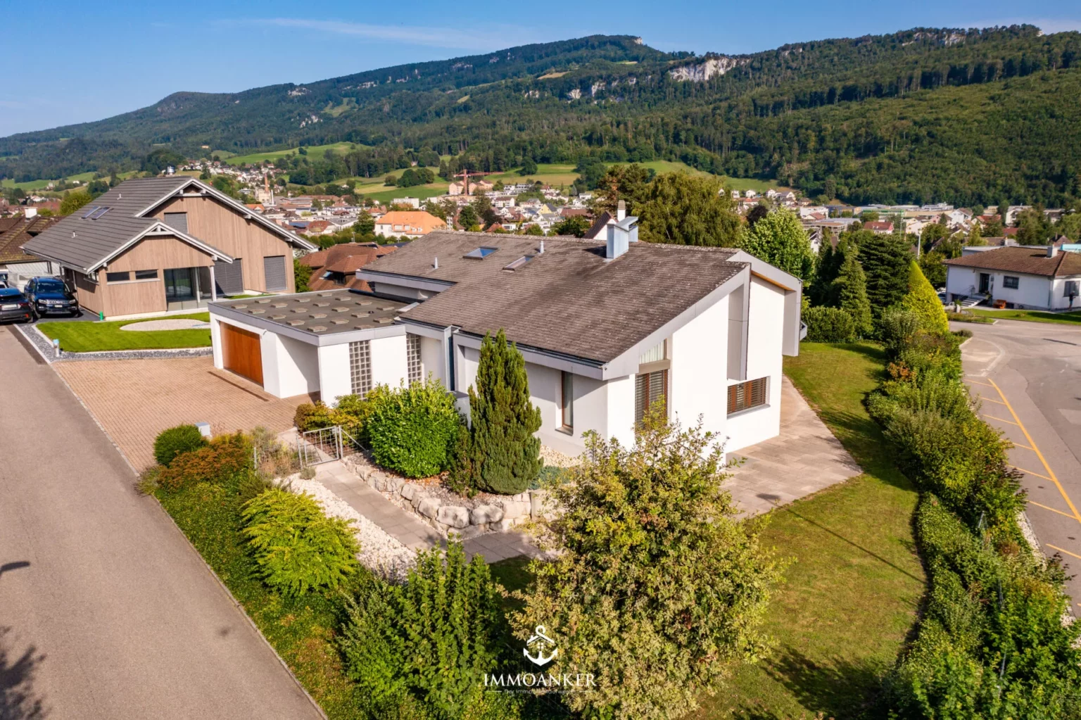 Luftaufnahme eines gepflegten Einfamilienhauses in Hanglage