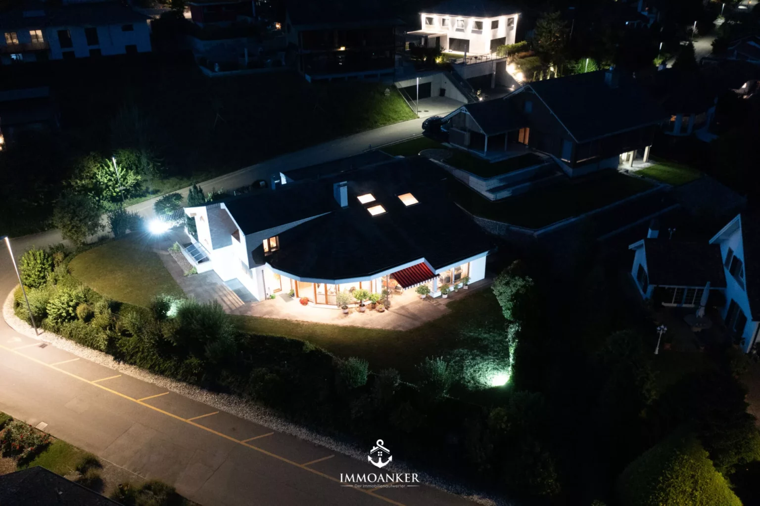 Luftaufnahme eines beleuchteten Wohnhauses bei Nacht