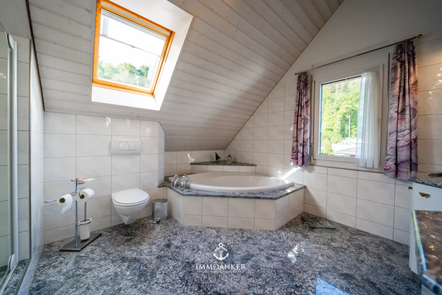 Dachgeschossbad mit Wanne und Dachfenster