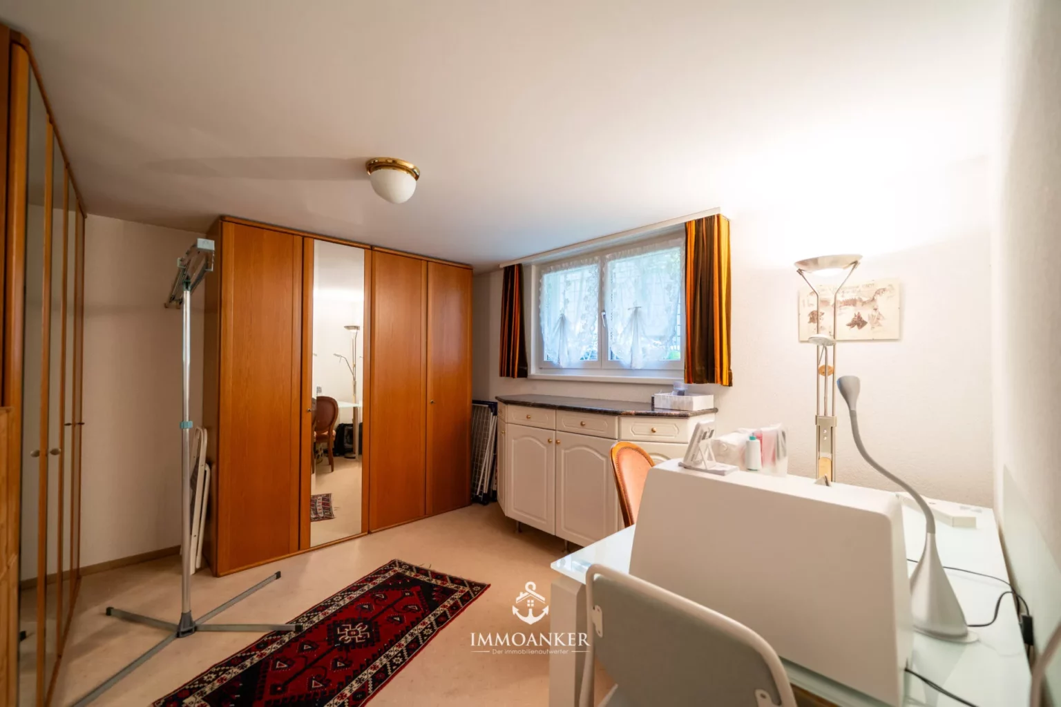 Helles Zimmer mit Schrankwand und Arbeitsbereich