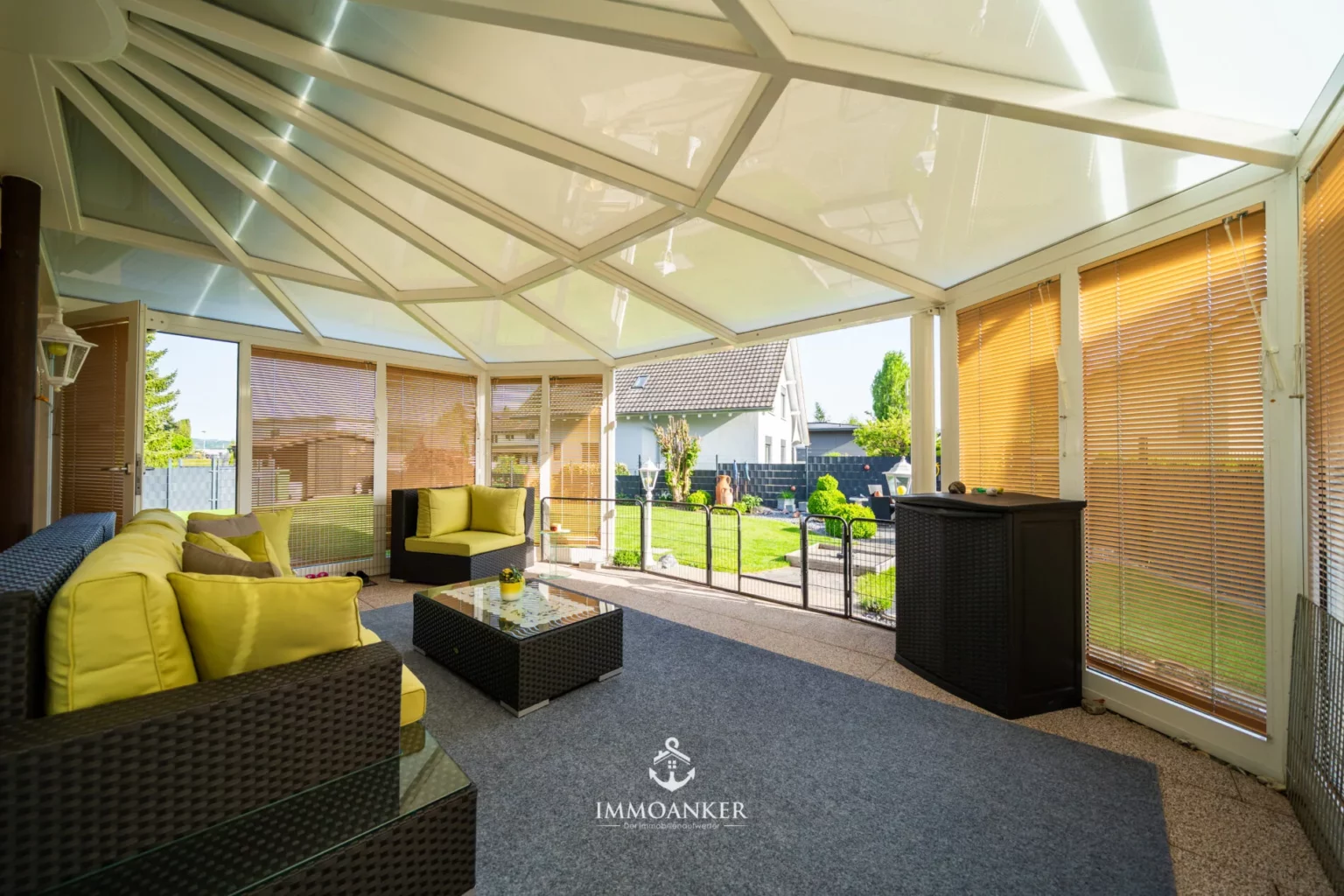 Verglaster Wintergarten mit Lounge-Möbeln