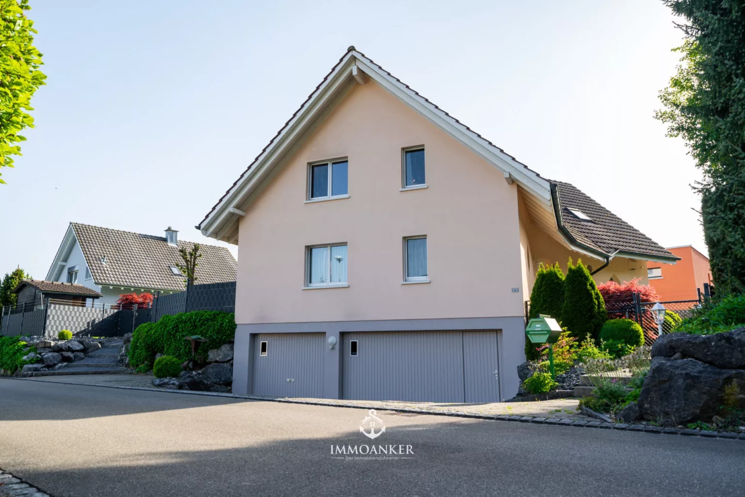Ein freistehendes Einfamilienhaus mit Satteldach und Doppelgarage