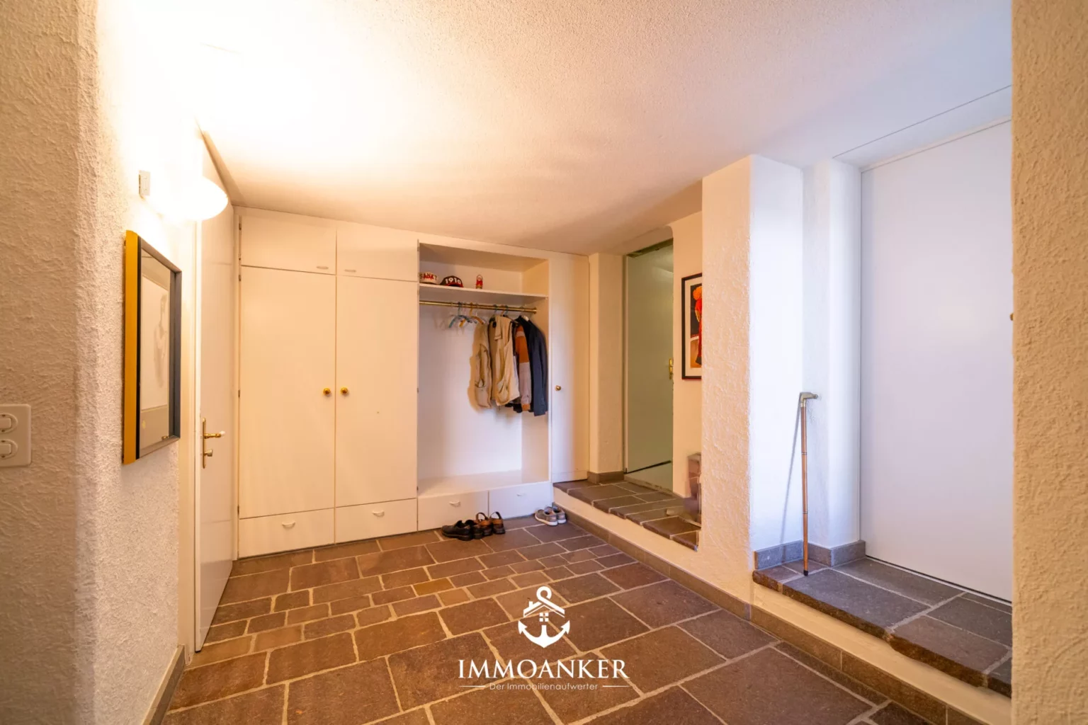 Eingangsbereich mit Steinboden und Garderobe