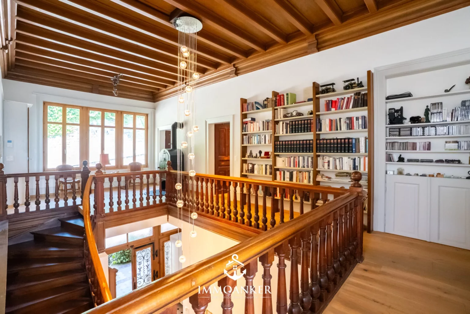Großzügiges Treppenhaus mit Galerie und Bücherregalen