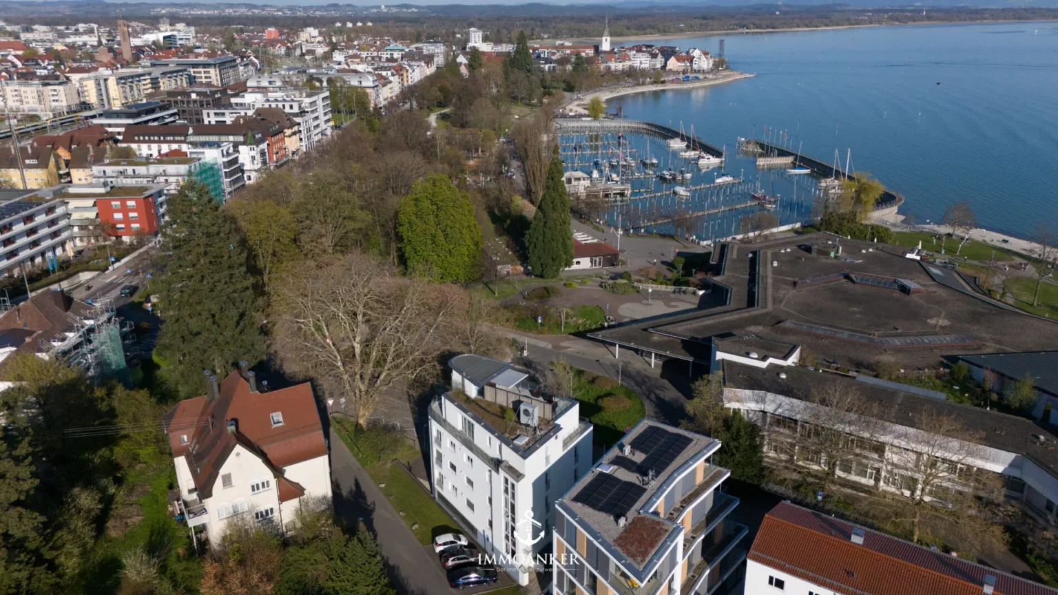 Luftaufnahme einer Uferlage mit Hafen und Wohnbebauung