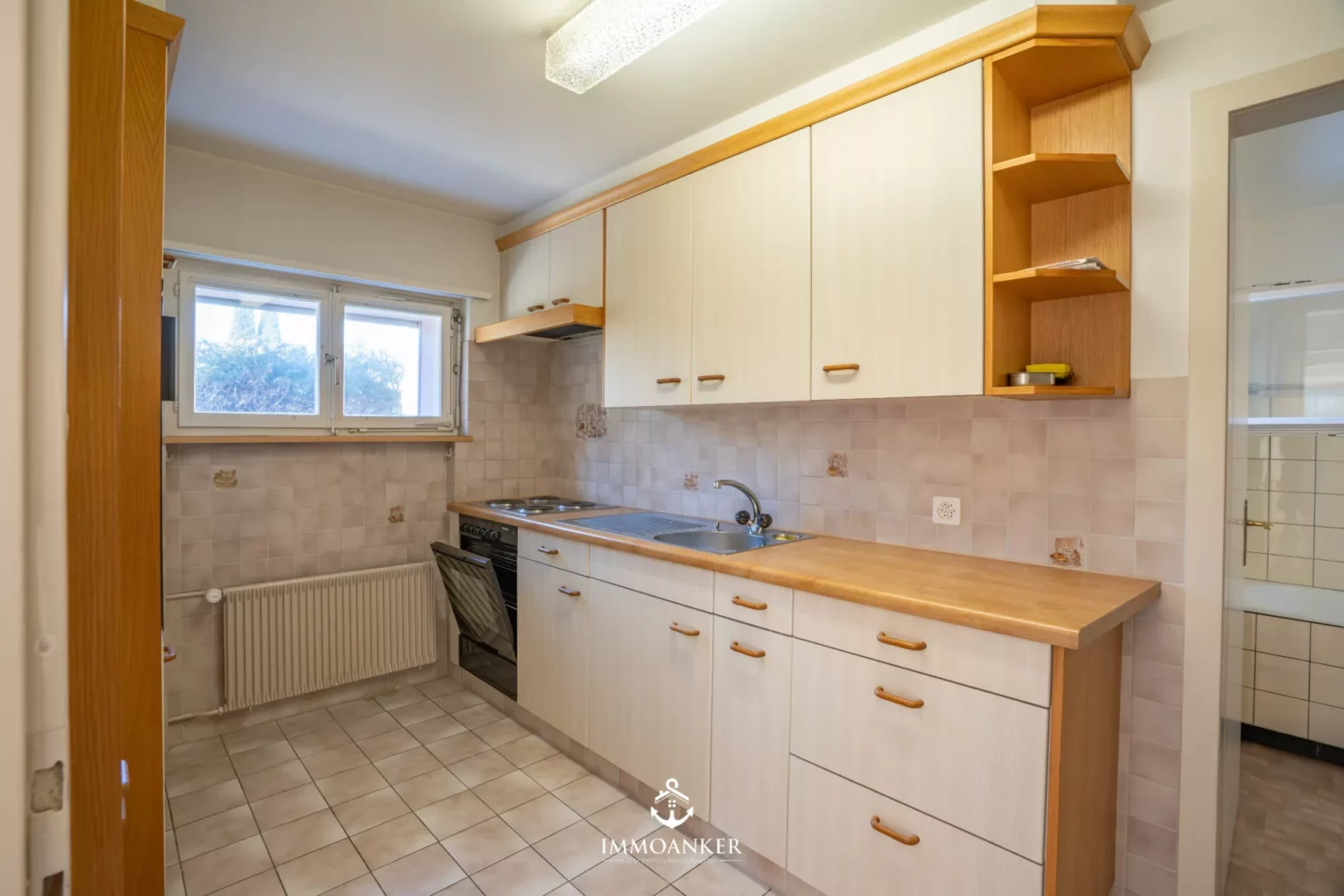 Kompakte Küche mit Fenster und Holzfronten