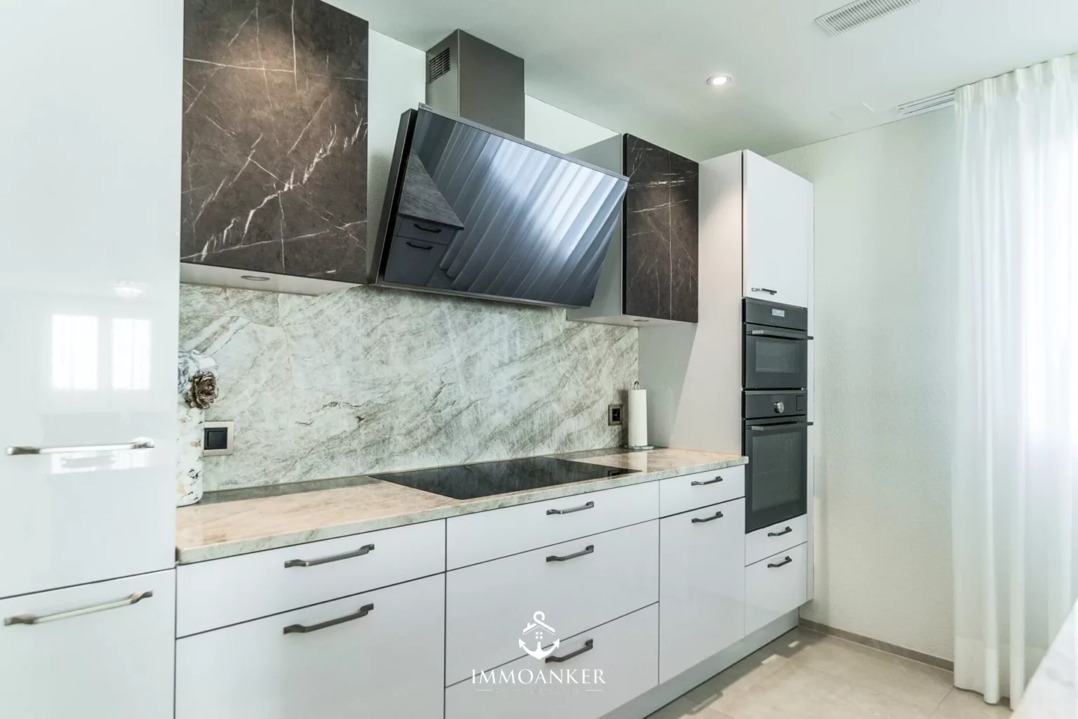 Moderne Küche mit Marmoroptik und Hochschrank