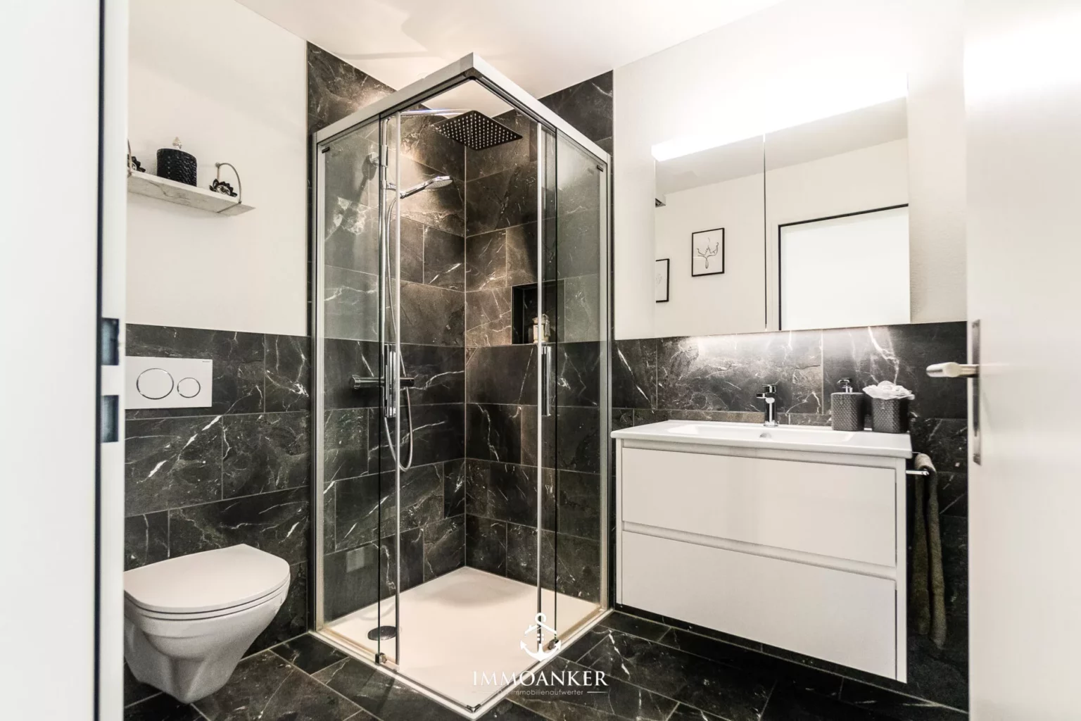 Modernes Badezimmer mit dunkler Steinoptik und Glasdusche