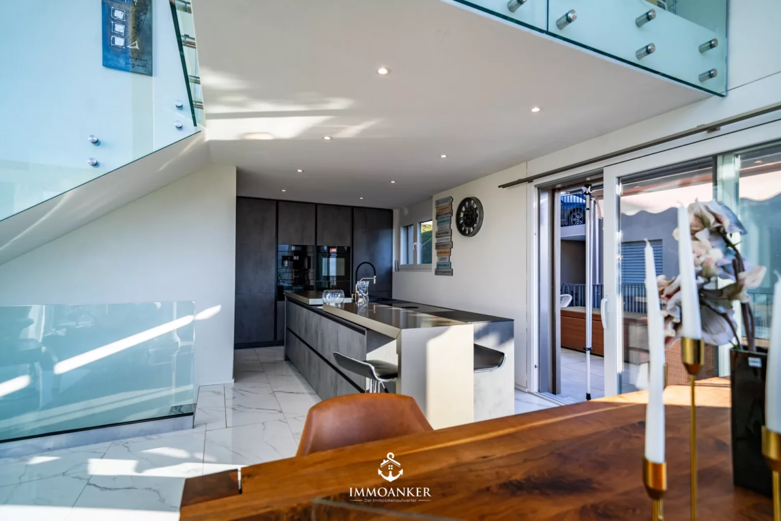 Moderne offene Küche mit Essbereich und Zugang zur Terrasse