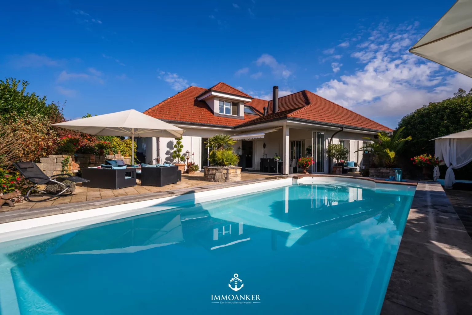 Poolbereich mit mediterranem Einfamilienhaus