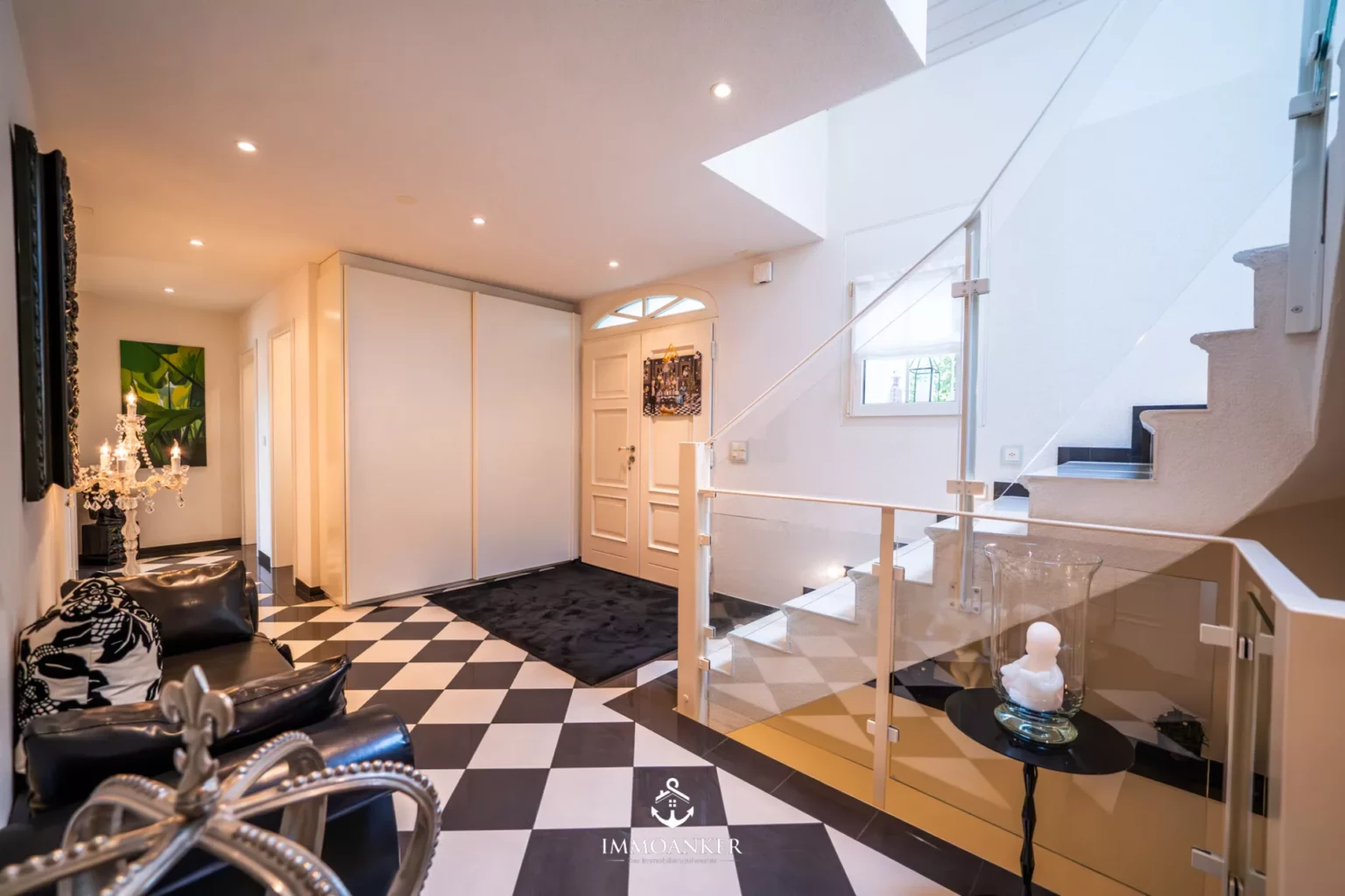 Eleganter Eingangsbereich mit Treppe und Schachbrettboden