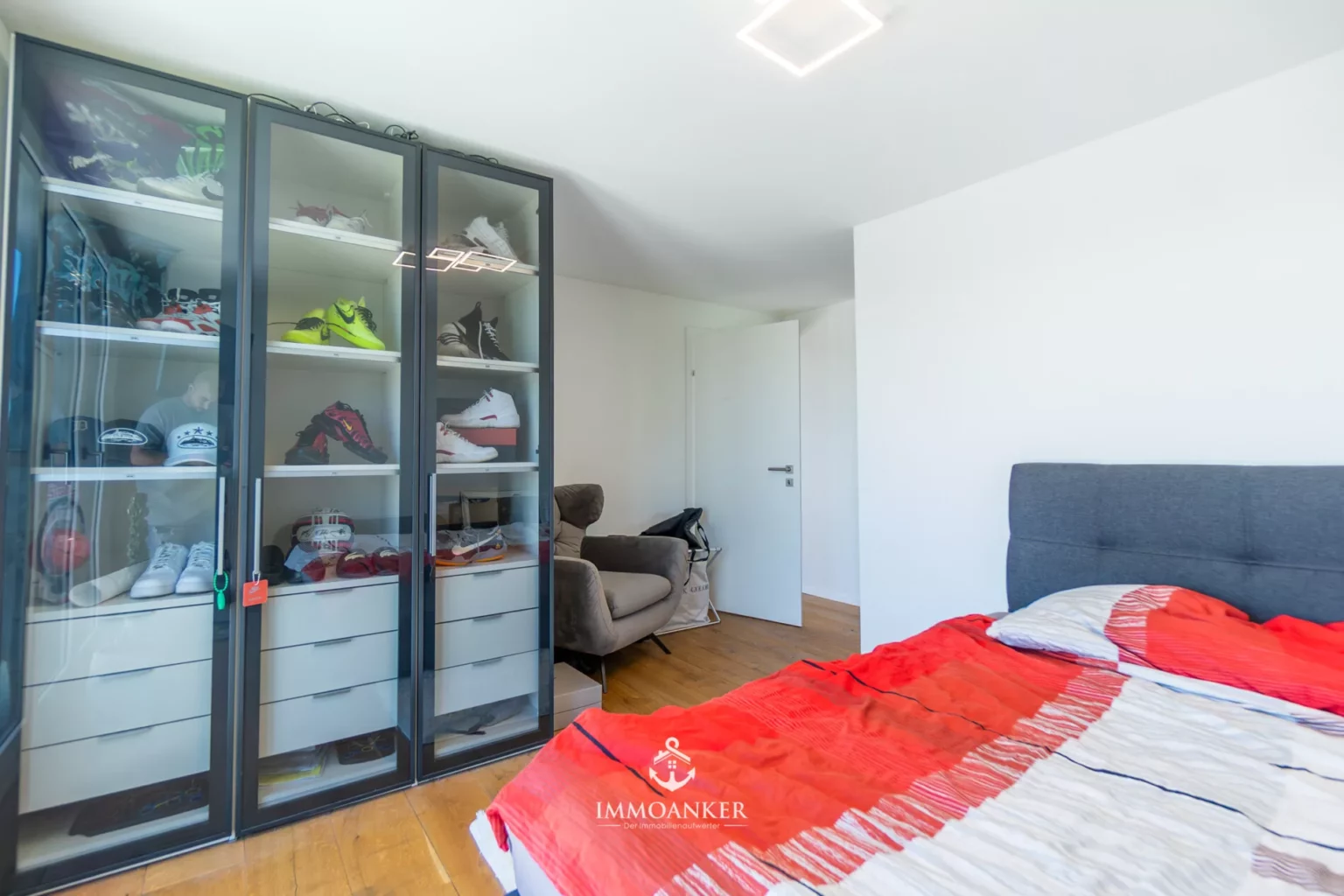 Schlafzimmer mit Glasvitrine und Bett