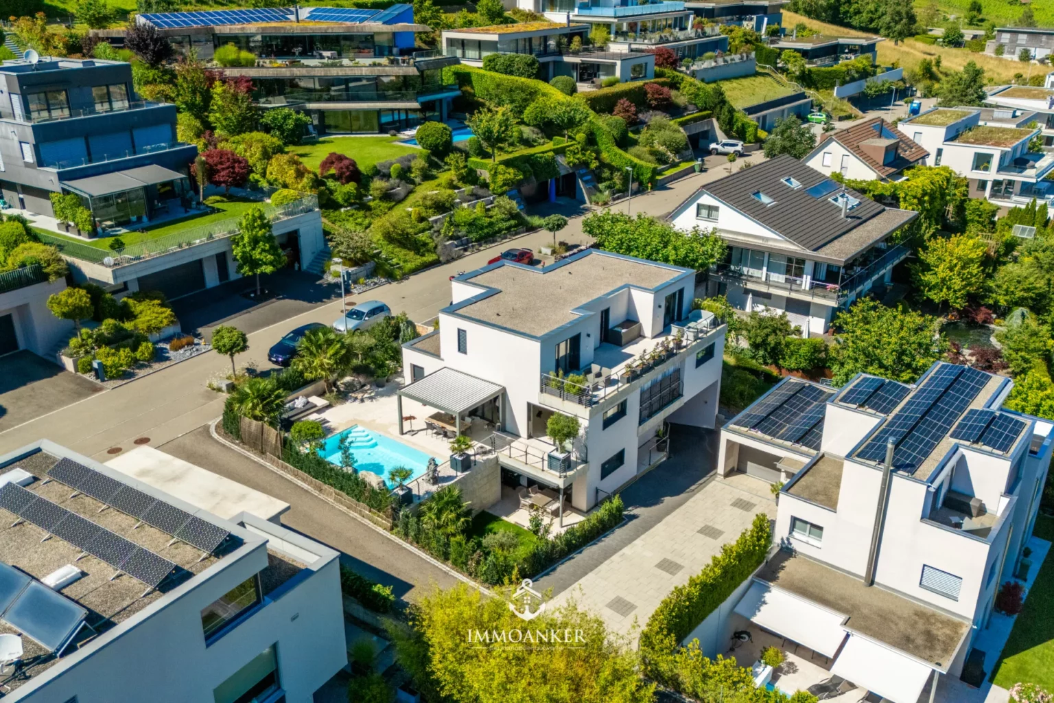 Luftaufnahme eines modernen Wohngebiets mit Villen und Pool