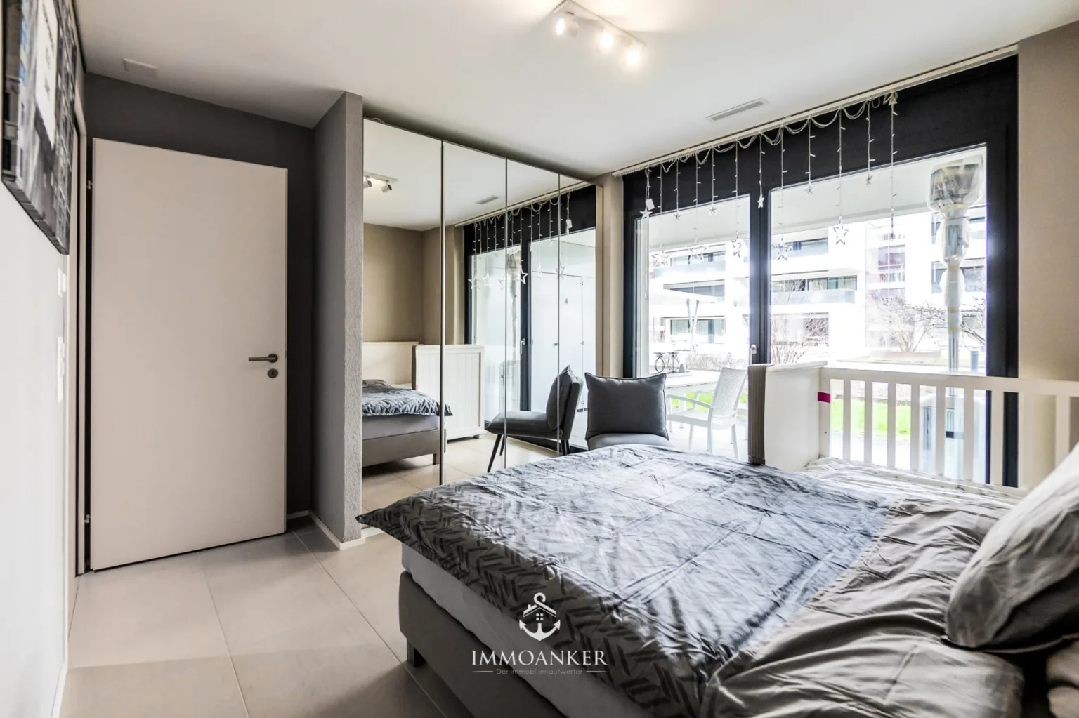 Helles Schlafzimmer mit Balkon und Spiegelschrank