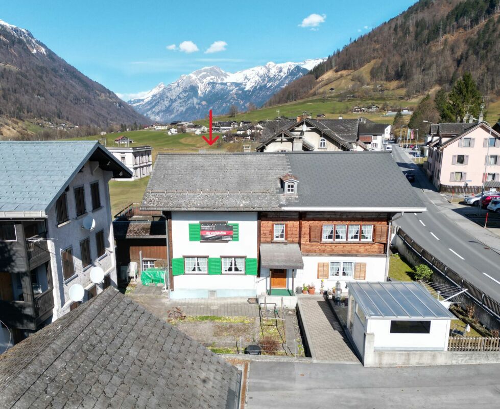 Alpenhaus mit Bergpanorama und Straße