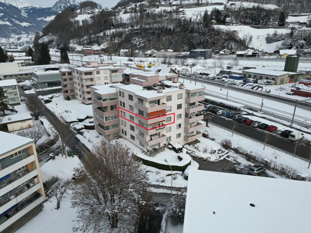 Luftaufnahme eines verschneiten Wohngebäudes mit markierter Wohnung