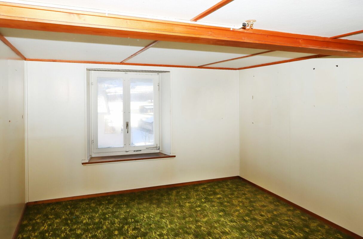 Zimmer mit grünem Teppich und Dachbalken