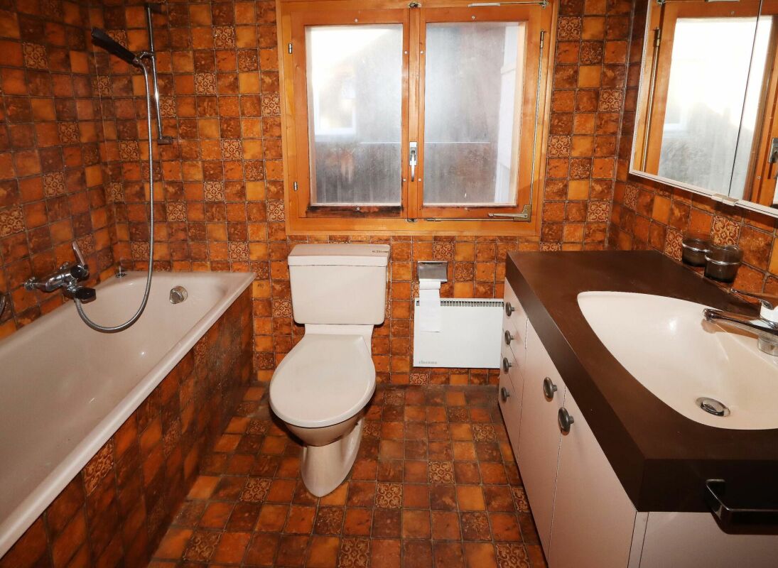 Kleines Badezimmer mit Badewanne und Waschtisch