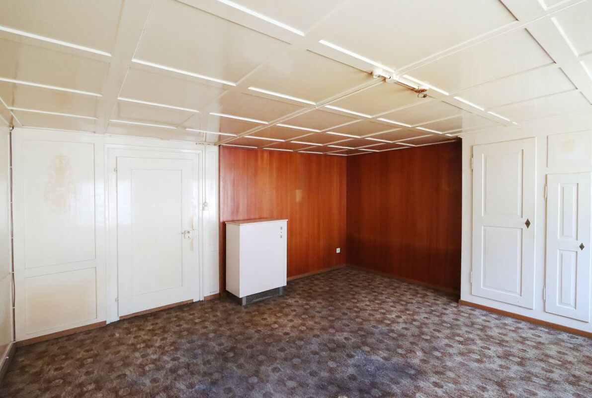 Leerer Innenraum mit Holzverkleidung und weißen Türen