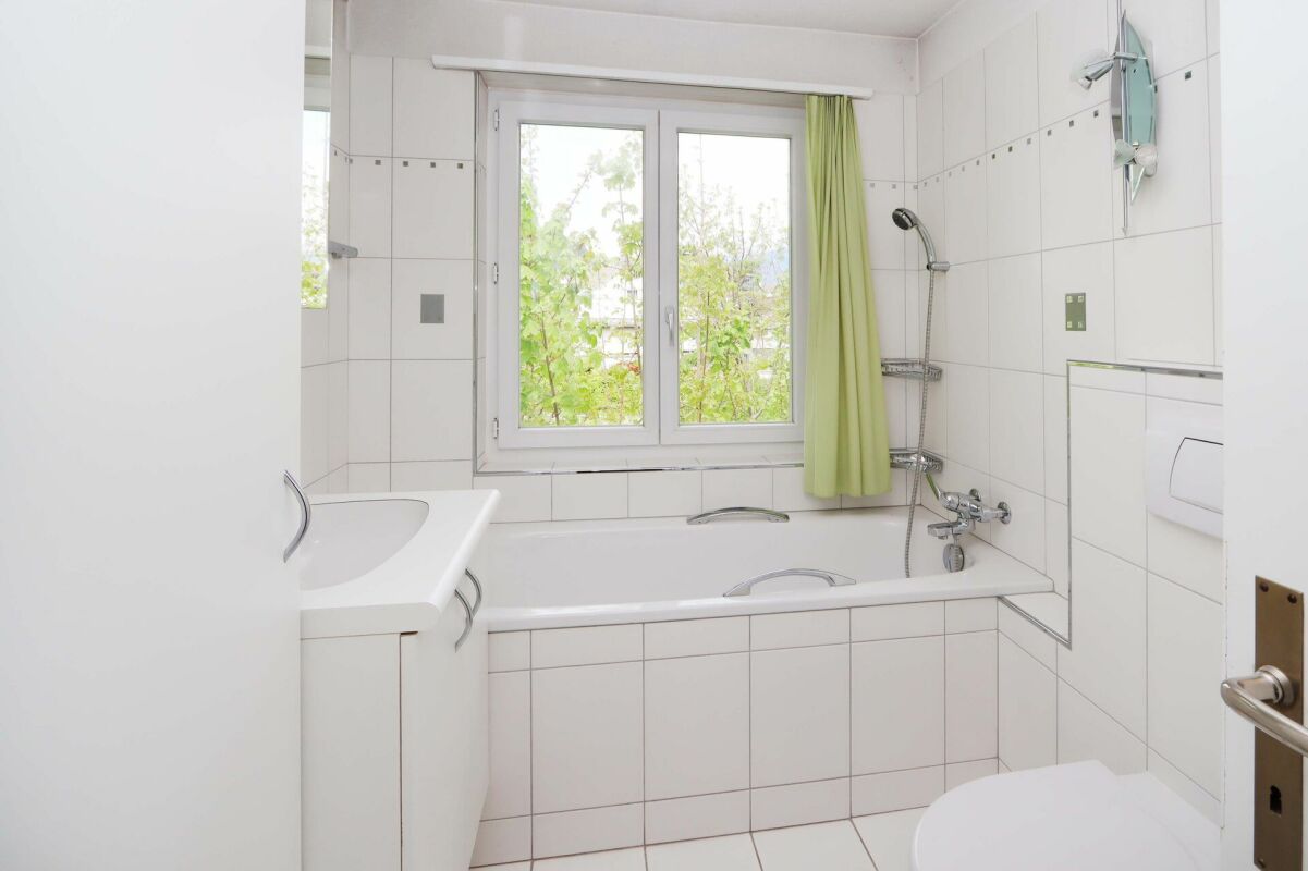 Helles Badezimmer mit Badewanne und Fenster