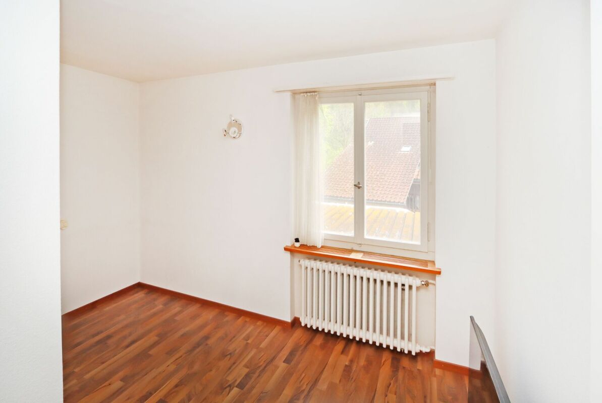 Heller leerer Raum mit Parkett und Fenster