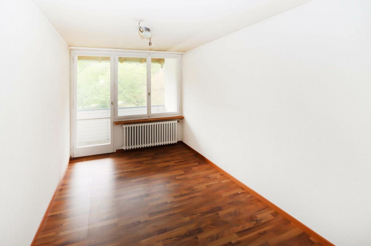 Helles, leeres Zimmer mit Holzfußboden