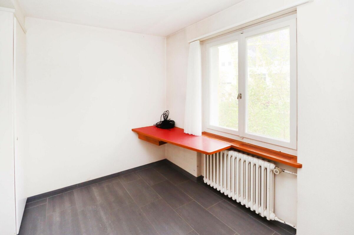 Kleines, helles Zimmer mit Fenster und Heizkörper