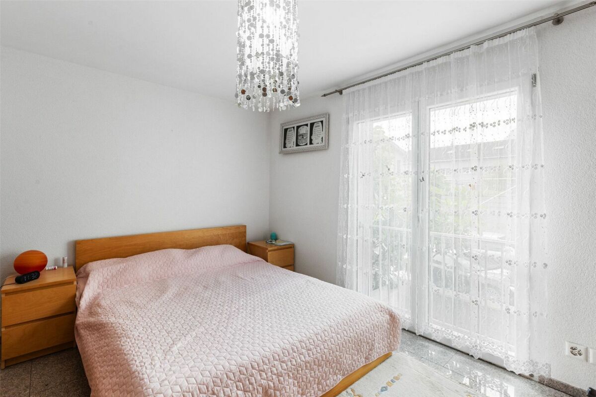 Helles Schlafzimmer mit Doppelbett und Balkonzugang
