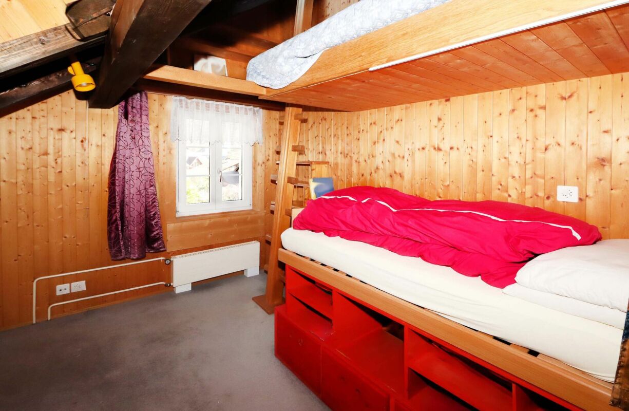 Dachzimmer mit Einzelbett und Holzausbau