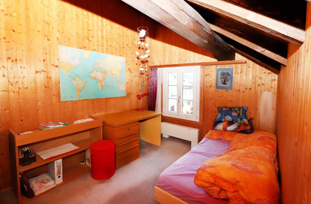 Dachzimmer mit Einzelbett und Schreibtisch