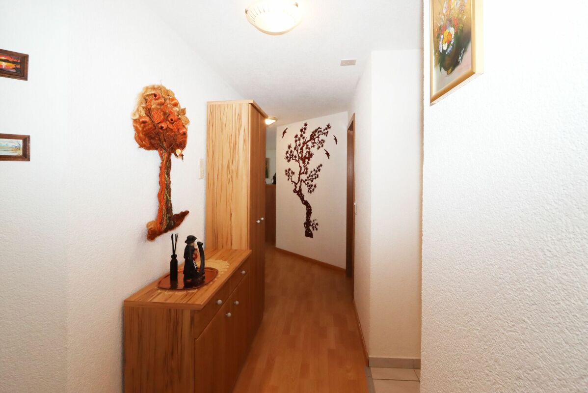 Heller Flur mit Holzmöbeln und Wanddekoration