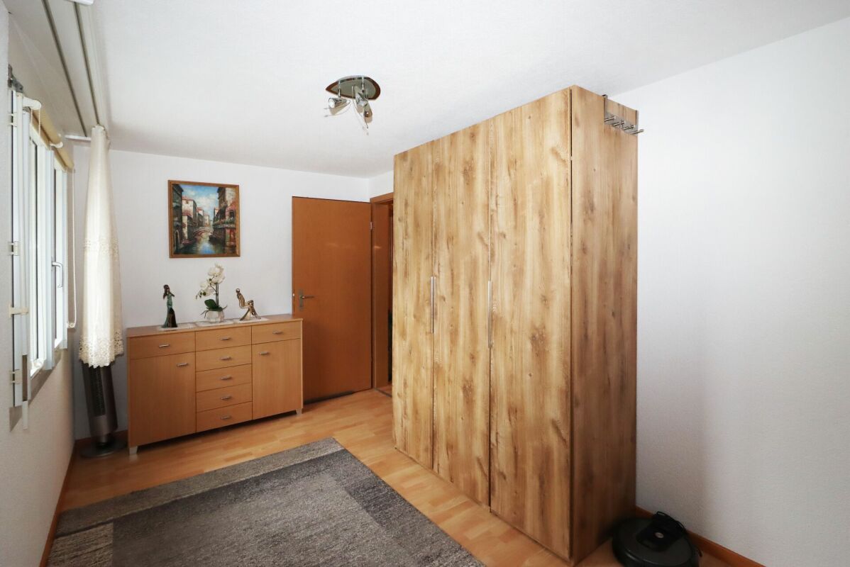 Helles Schlafzimmer mit Kleiderschrank und Kommode