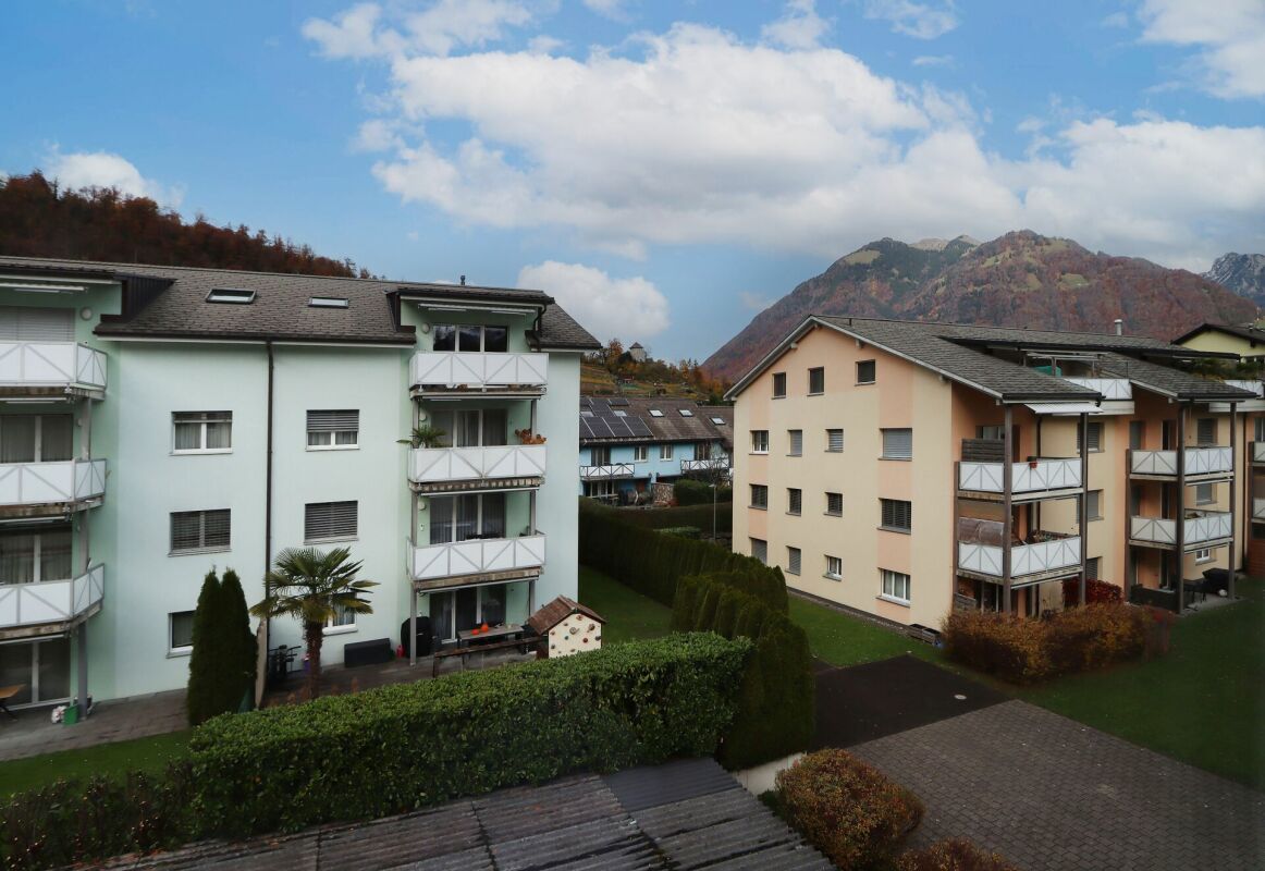 Balkonblick auf Mehrfamilienhäuser mit Bergkulisse