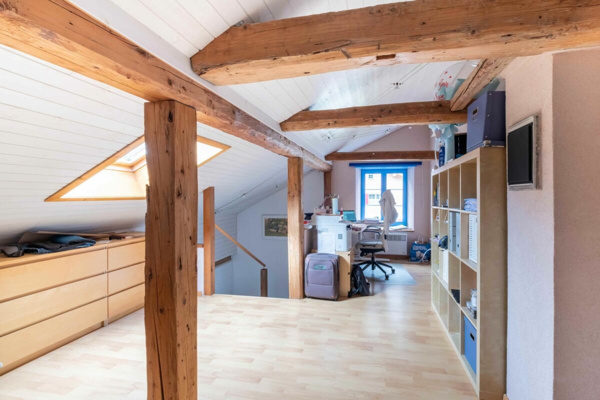 Dachgeschoss-Arbeitsraum mit sichtbaren Holzbalken