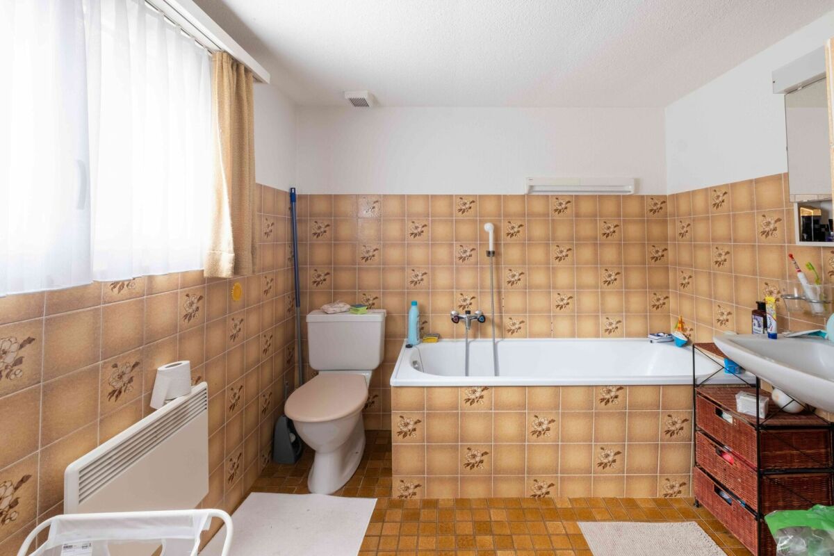 Badezimmer mit Badewanne und WC