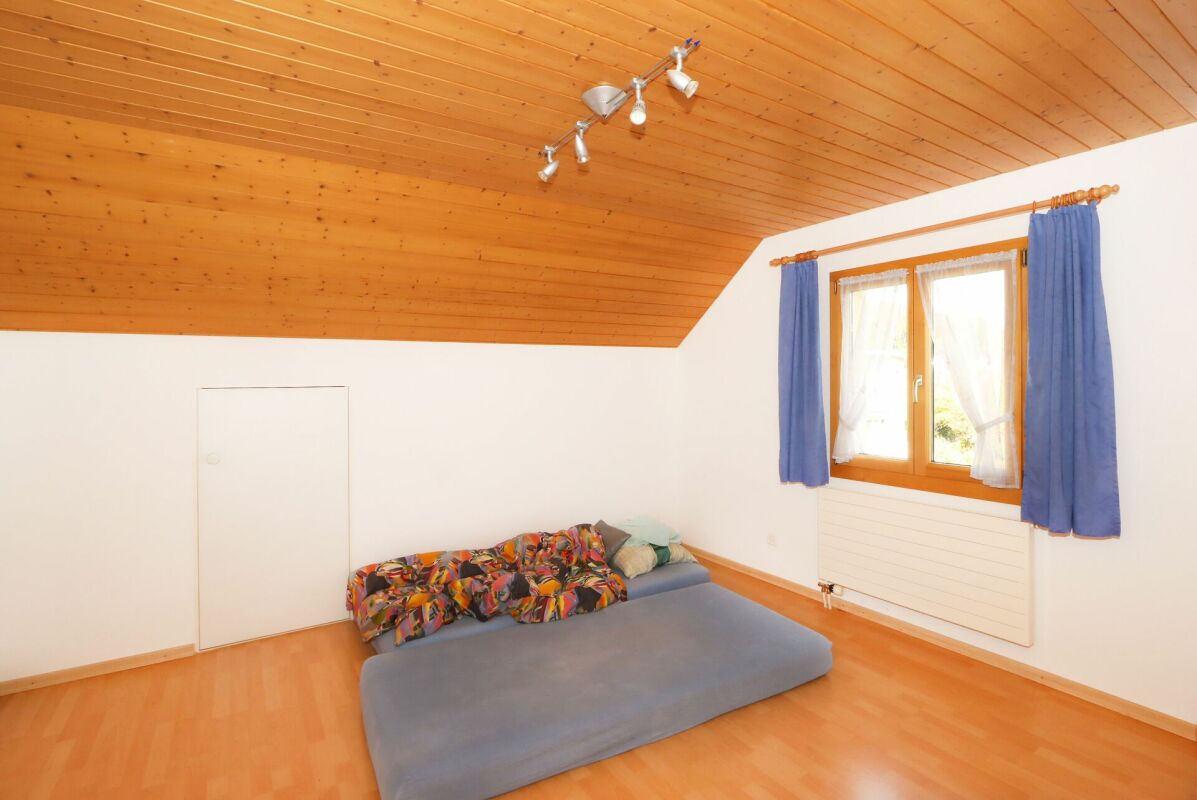 Dachzimmer mit Holzdecke und Einzelbett