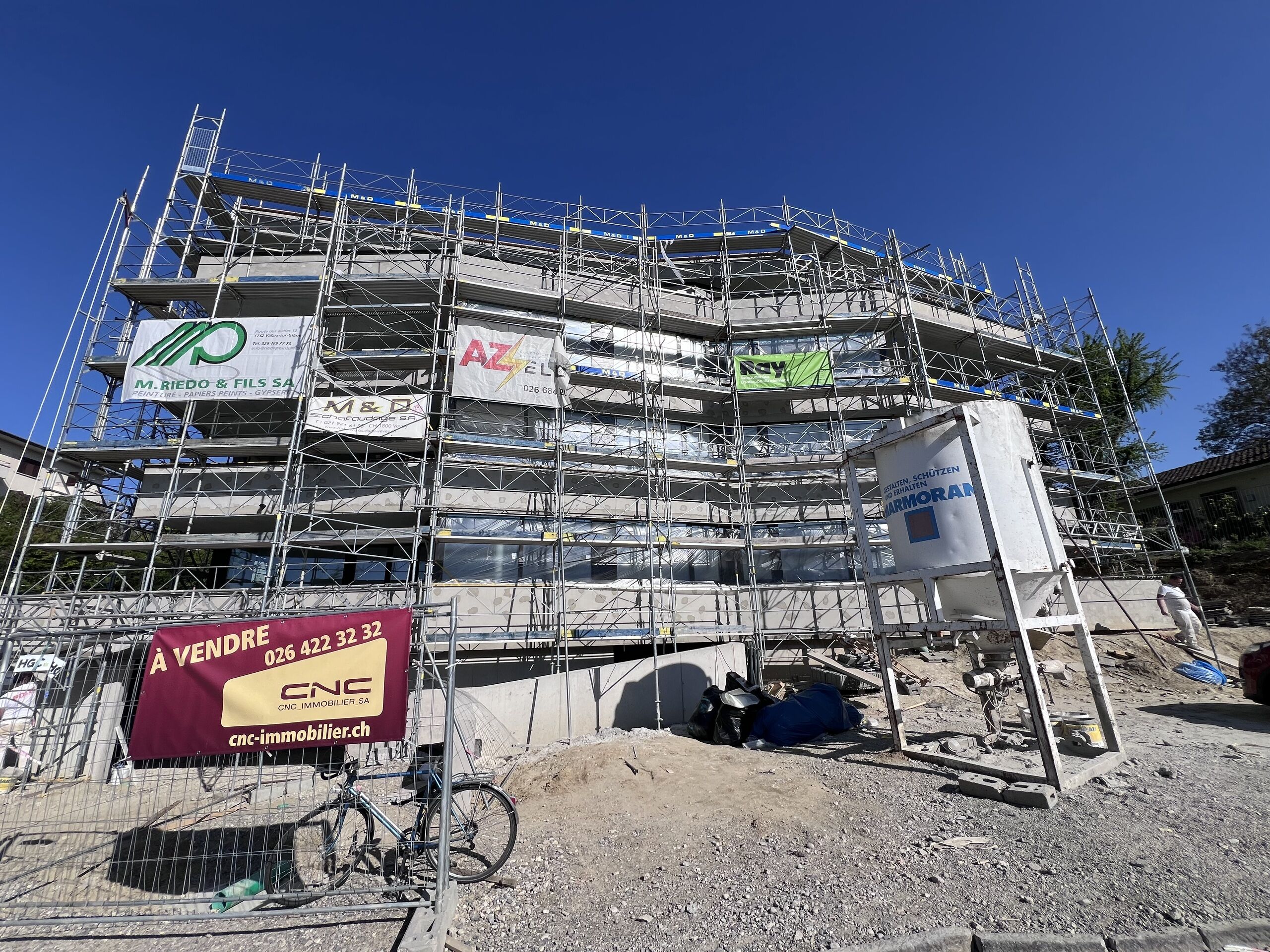 Mehrstöckiges Gebäude im Bau mit Gerüst und Verkaufshinweis