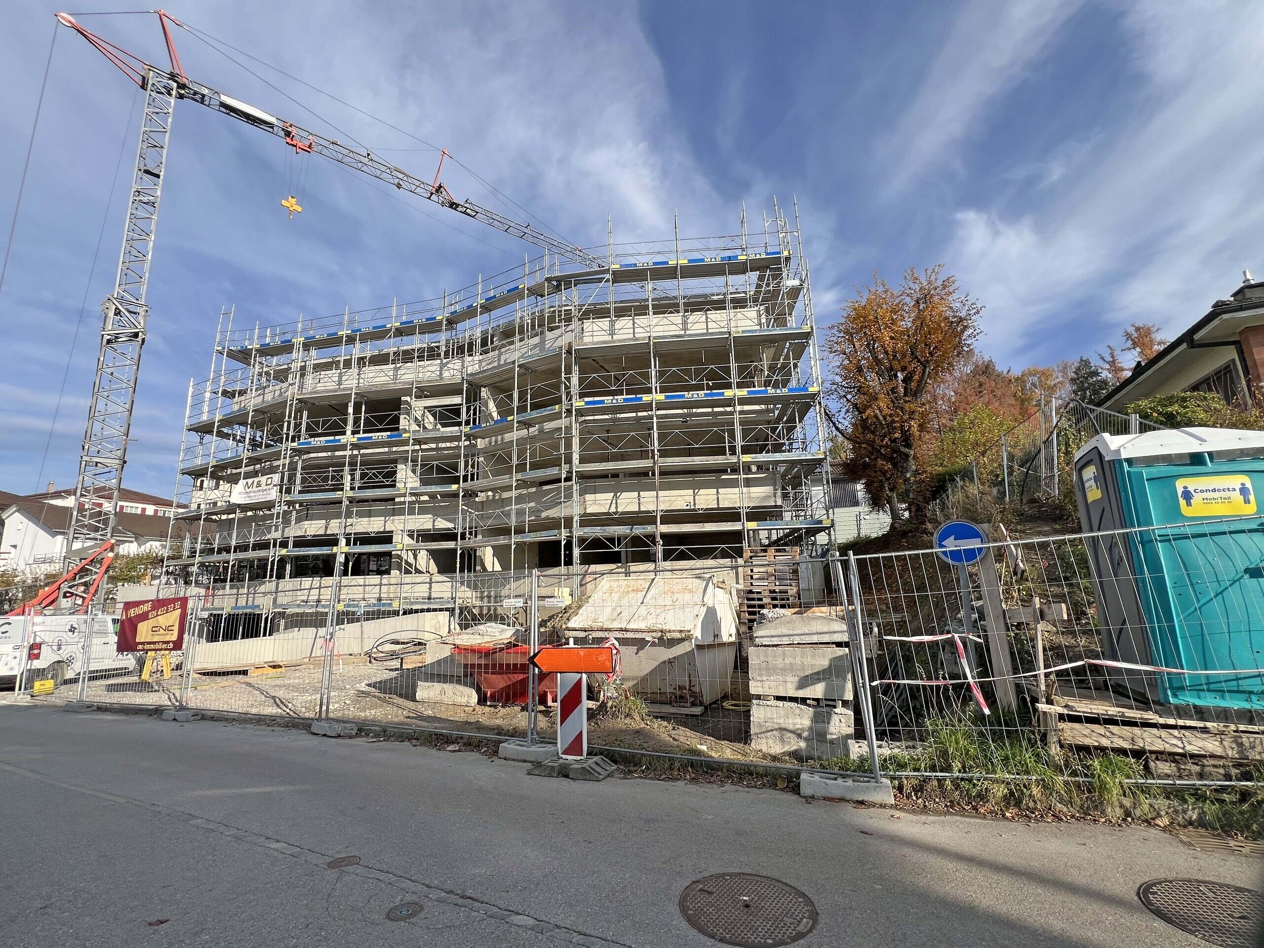 Wohngebäude im Bau mit Gerüst und Kran