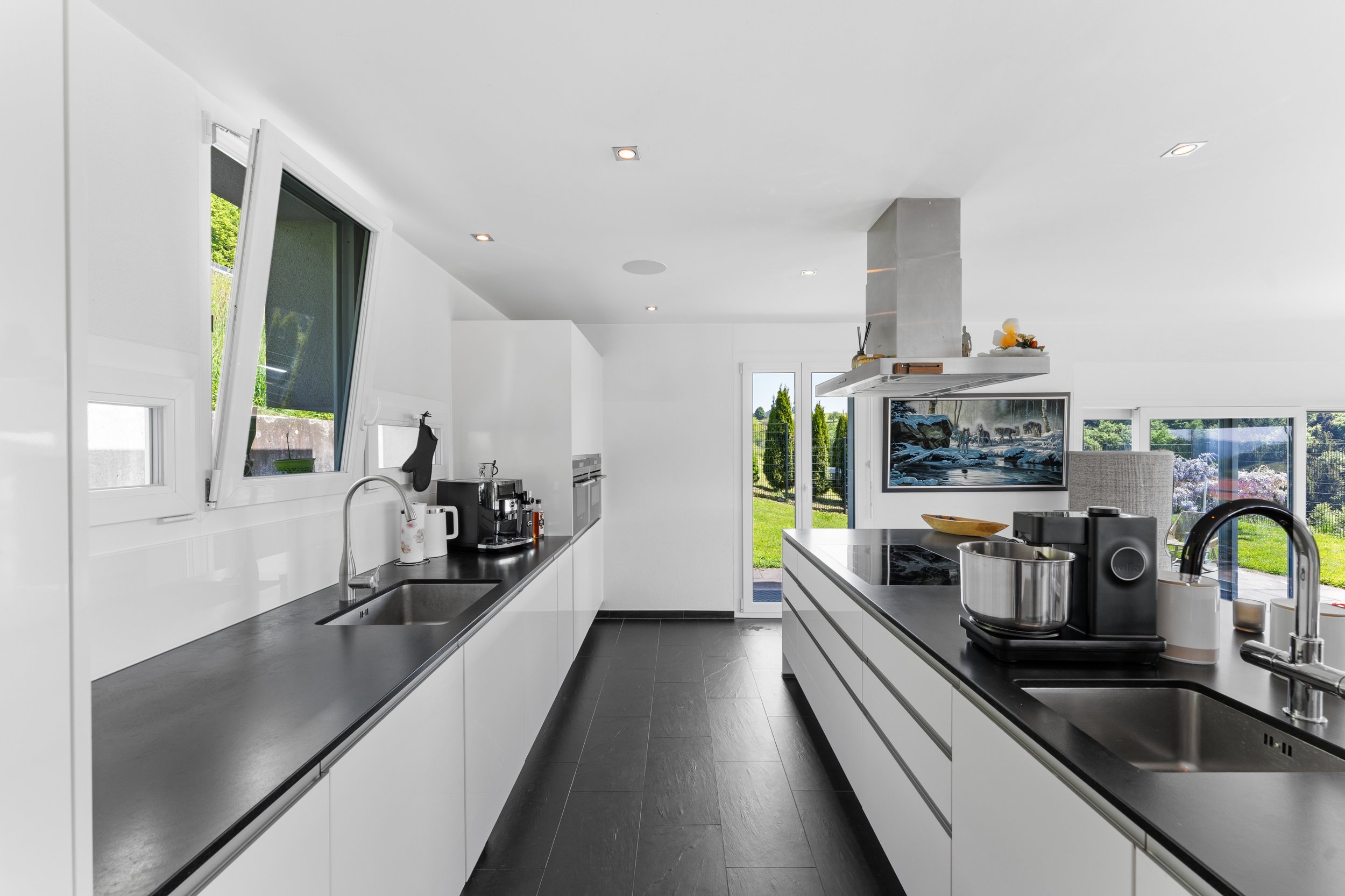 Moderne offene Küche mit Insel und Gartenblick