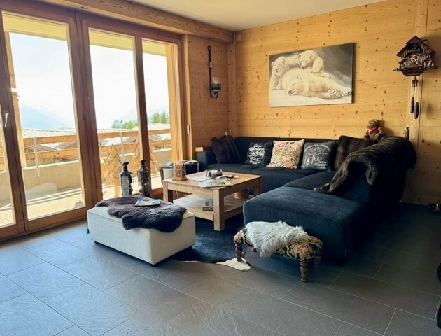 Gemütlicher Wohnraum mit Holzwänden und Terrassenzugang