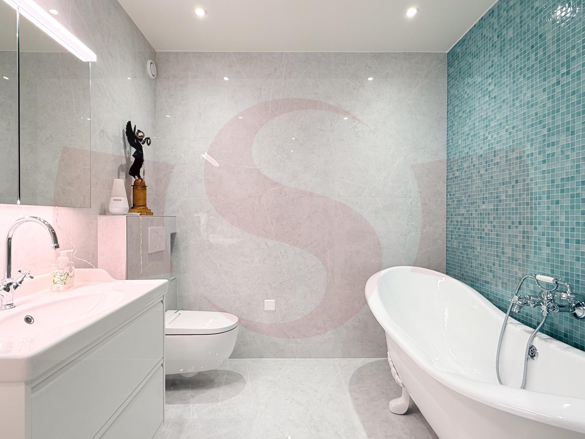 Modernes Badezimmer mit freistehender Wanne und türkisfarbener Akzentwand